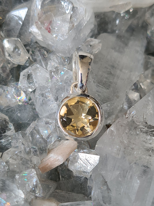A round faceted citrine set pendant in sterling silver