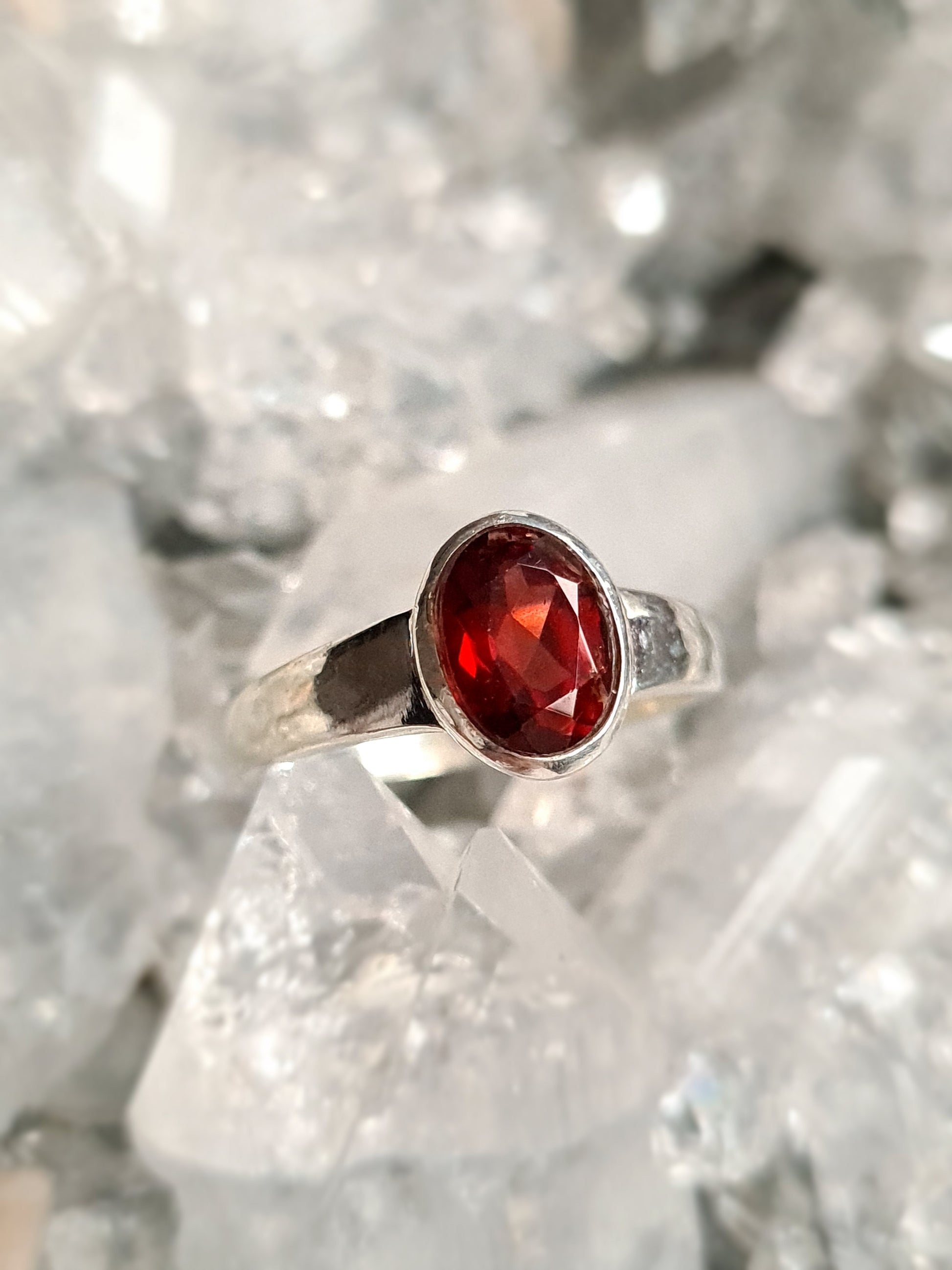 A sterling silver ring set with an oval faceted red garnet. Sizes N and P.5 available