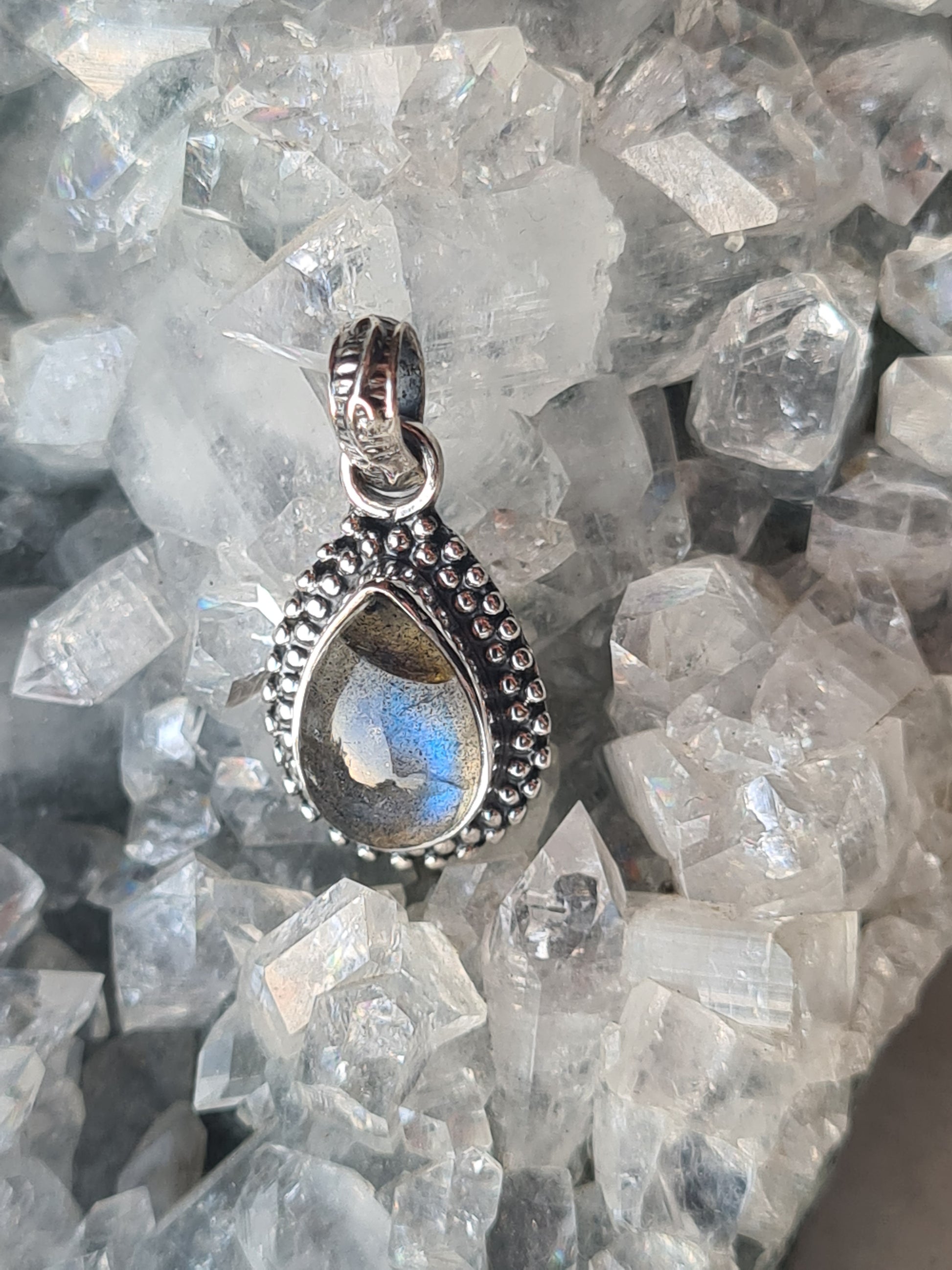 A Labradorite set pendant, with centre pear shaped cabochon, beaded frame and articulating textured bail. Labradorite shows blue flash.