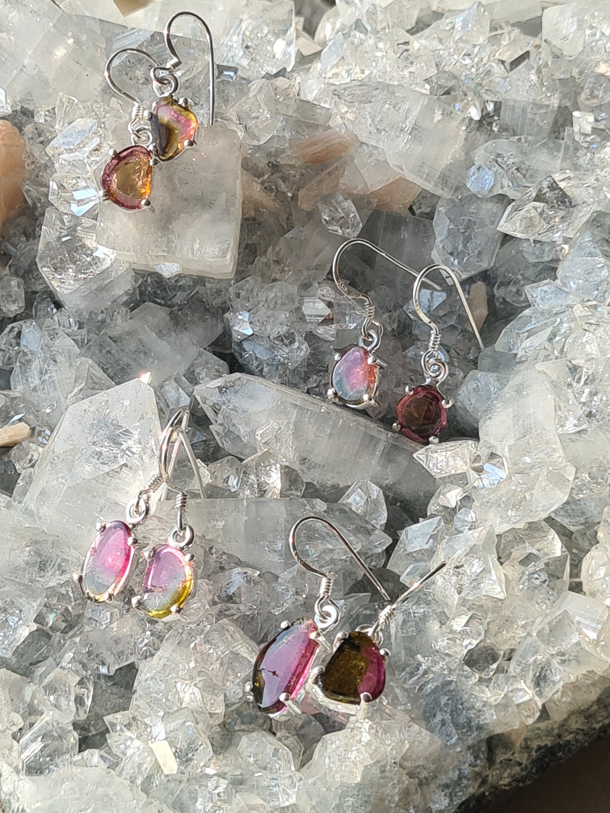 Our watermelon tourmaline earring collection, showing 4 pairs of well matched watermelon tourmaline slice drop earrings in sterling silver. 
Photographed on a raw apophyllite cluster. 