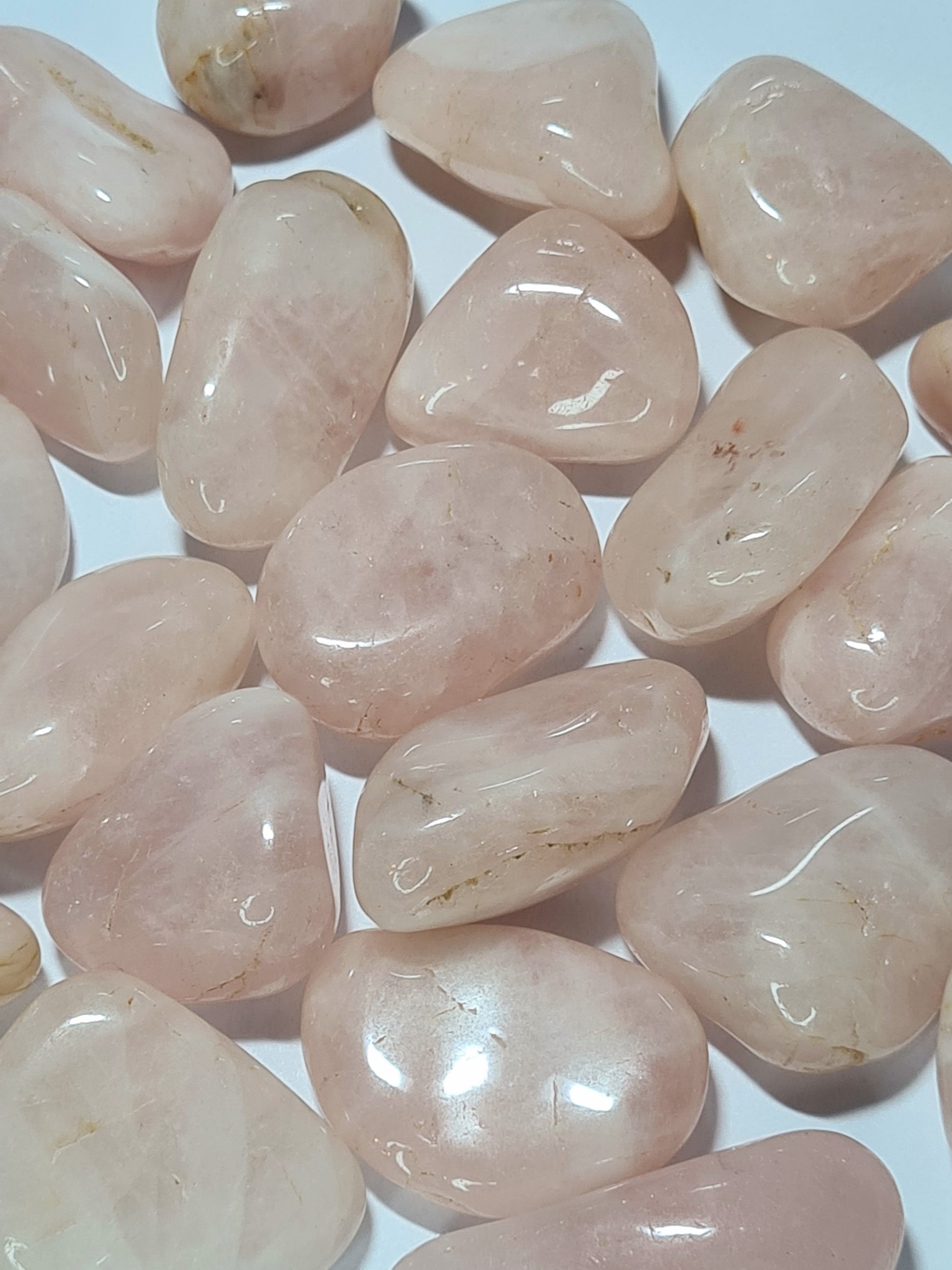 Natural Rose Quartz Pink Tumbles from India. Native Tumbled shape. Photographed on a white background. 