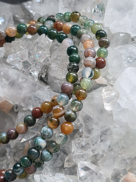 Three 4mm mixed agate beaded bracelets, in colours of green, red, orange and white. Photographed on an apophyllite cluster.