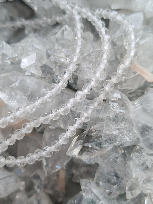 Natural Clear Quartz 3mm Faceted Bead Bracelets shown on crystal Cluster background. 