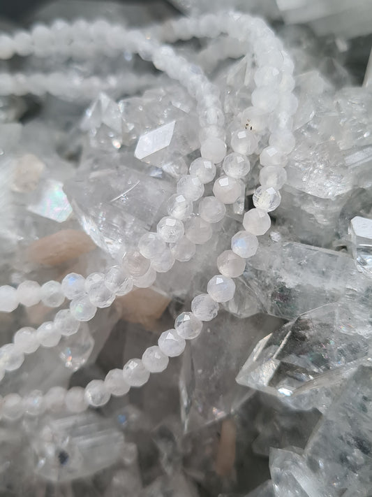Faceted white Moonstone bracelet 3mm size on elastic. Slight flashes of blue can be seen. Photographed on an apophyllite cluster. 