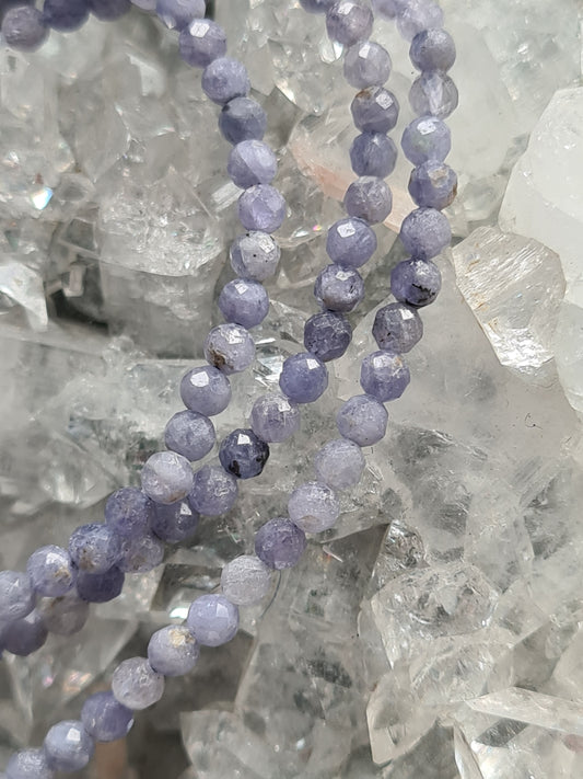 Three 3mm faceted bead Tanzanite bracelets,  photographed on an apophyllite cluster 