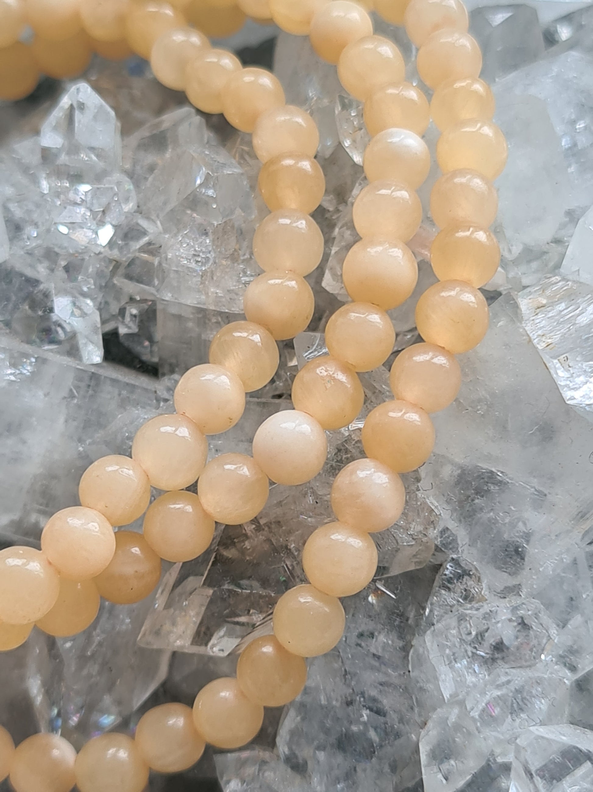 Natural Yellow Jade 4mm beaded bracelets. Varying shades of colour to each bracelet. 
Photographed on a raw apophyllite crystal. 