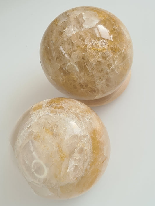 Golden Healer Quartz Spheres from Brazil. 68mm diameter. Photographed on a white background.
