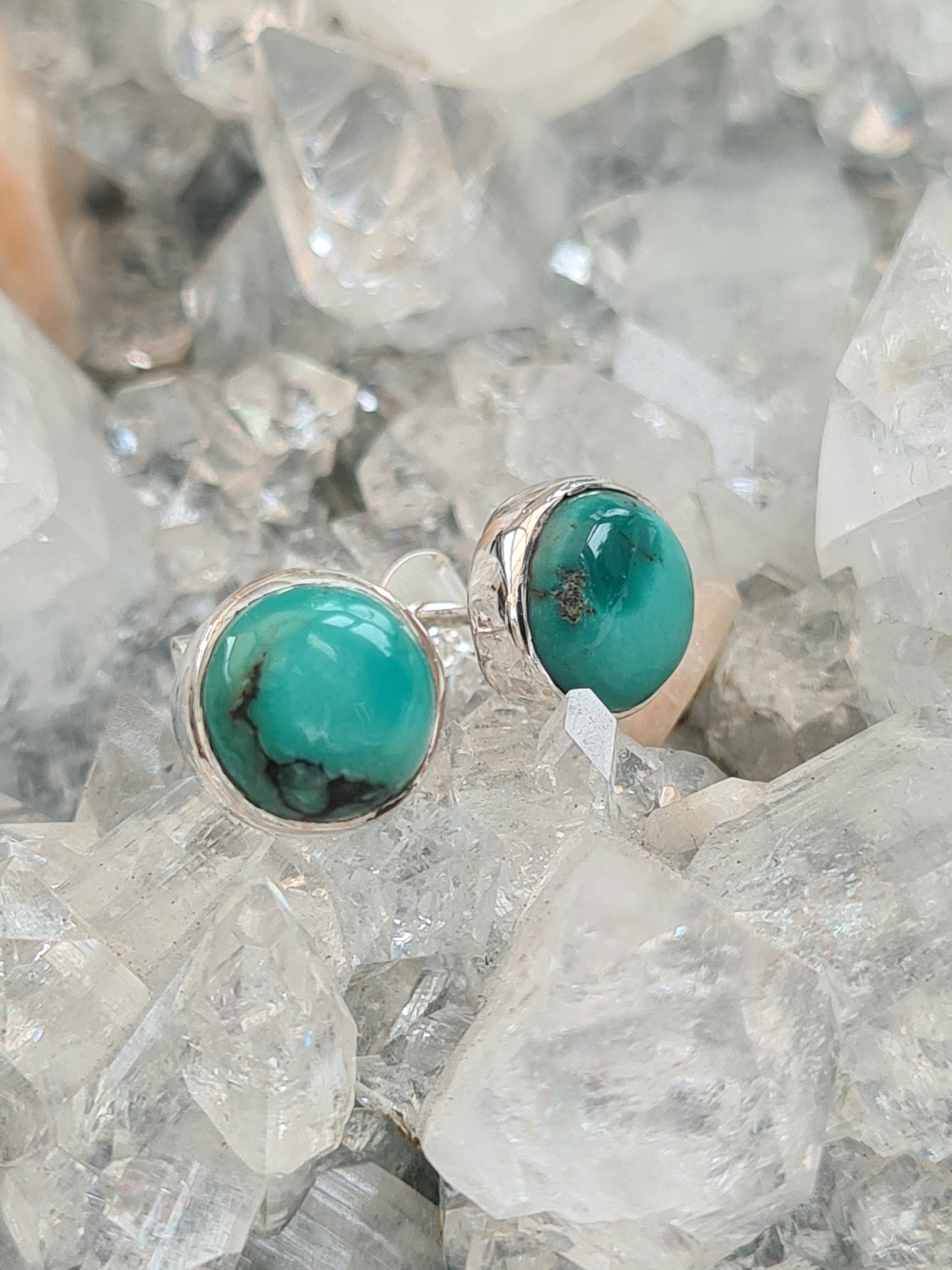 Natural Turquoise set stud earrings in sterling silver. Round shape. Photographed on an apophyllite cluster background. 