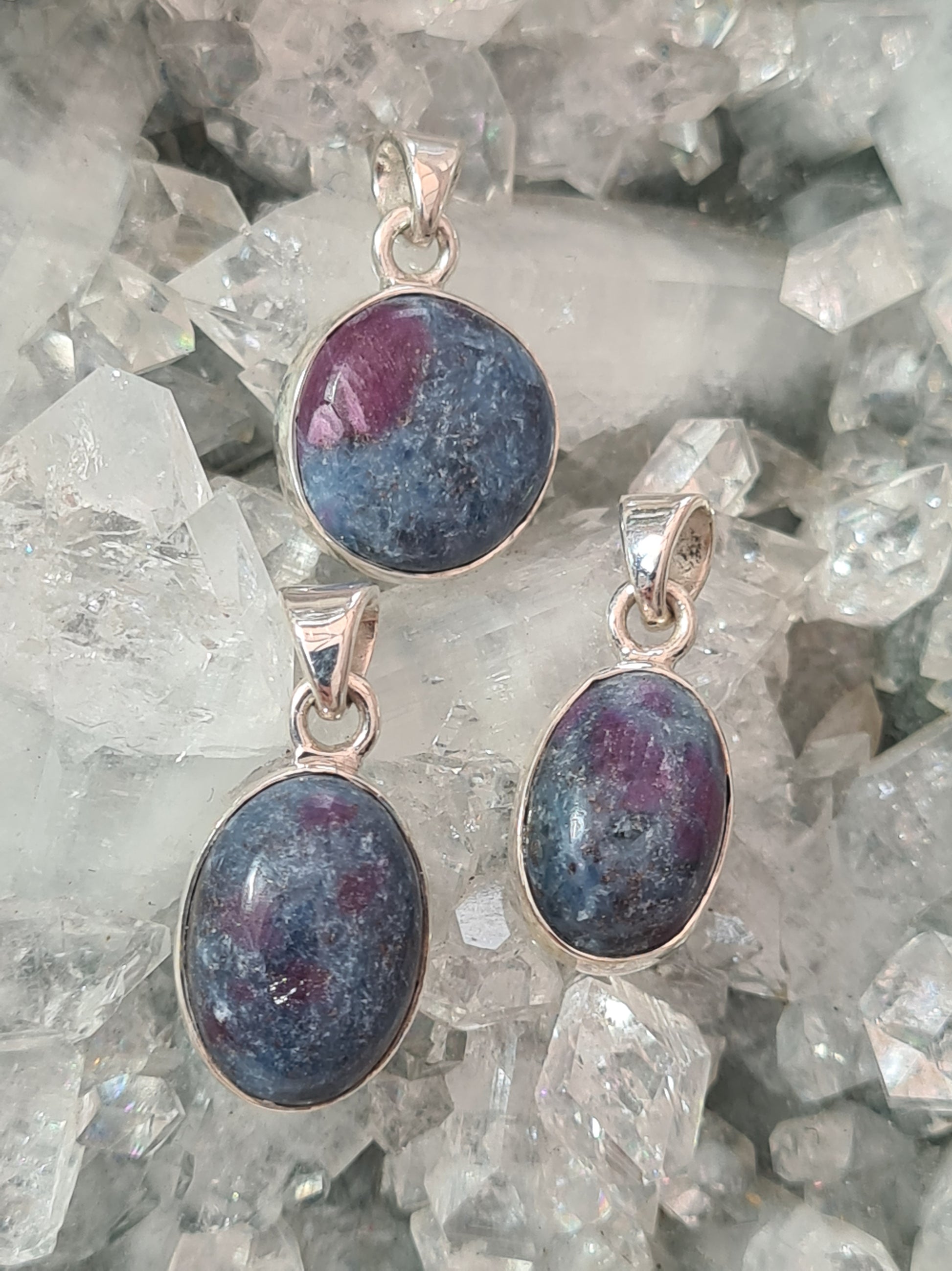 Three Natural Ruby in Blue Kyanite Pendants in Sterling Silver. Two oval shaped and one round shape.
Photographed on an apophyllite cluster background. 
