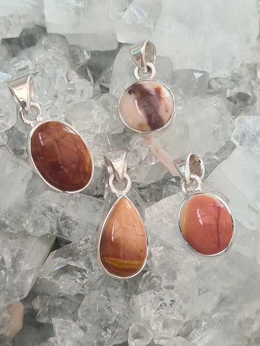 Collection of four mookaite pendasnts. Shown in round, oval or pear shape on crystallised background.