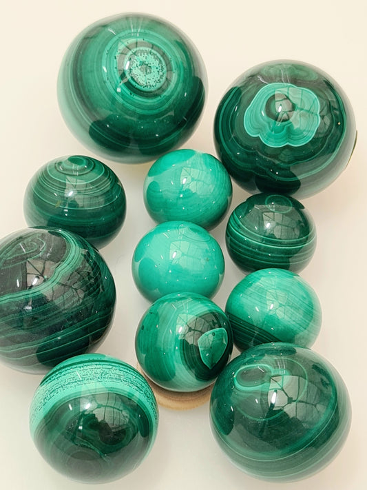 Full collection of malachite spheres, varying sizes from 11mm to 29mm diameter.
