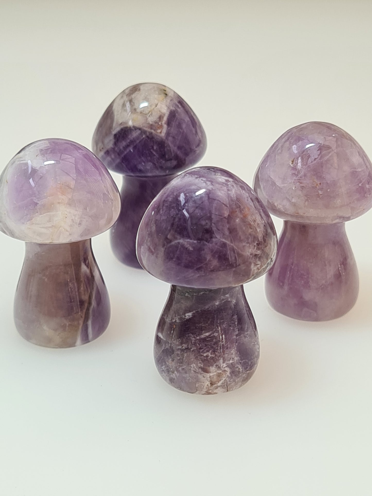 Natural dream amethyst 3.5cm mushroom carvings.
Photographed on a white background.