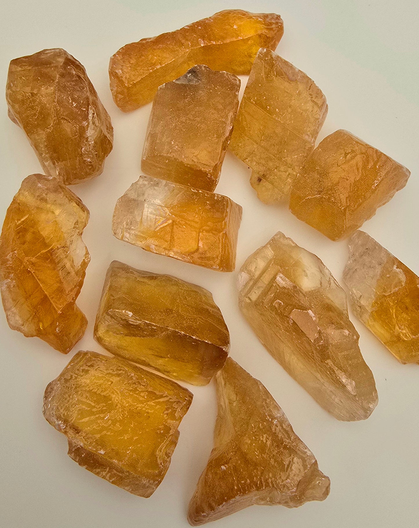 Small honey calcite Chunks photographed in daylight on white background