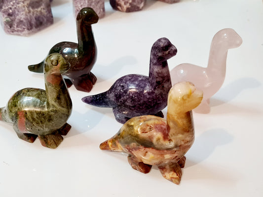 five crystal dinosaur carvings, lepidolite, rose quartz, unakite and crazy lace agate. Choose one which calls to you from the menu.