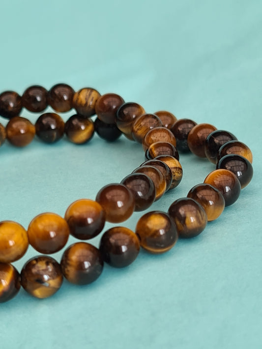Two Golden Yellow Tigers Eye 6mm beaded bracelets on blue background