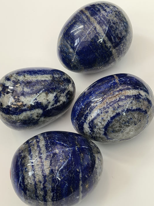 Collection of Lapis Lazuli Polished Egg Crystals. Naturally coloured blue, with white banding and pyrite spangles.
