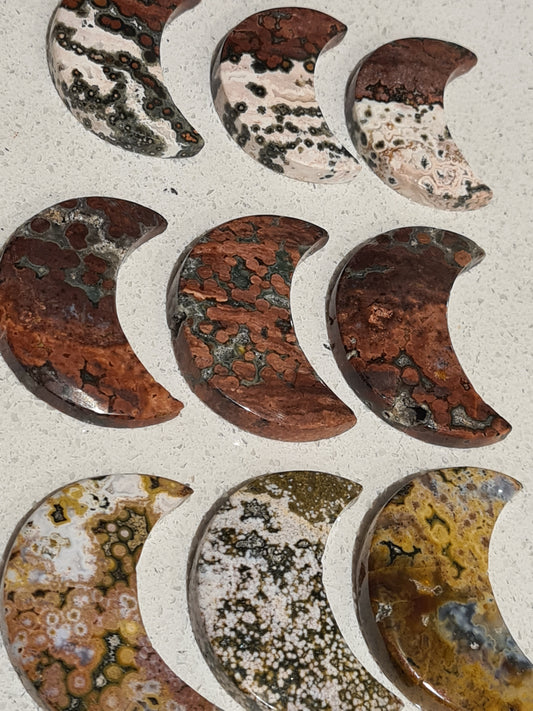 Natural orbicular jasper (OJ) crescent moon carvings. Approx 2 inches in height. with colours of red, green, white or yellow mix.