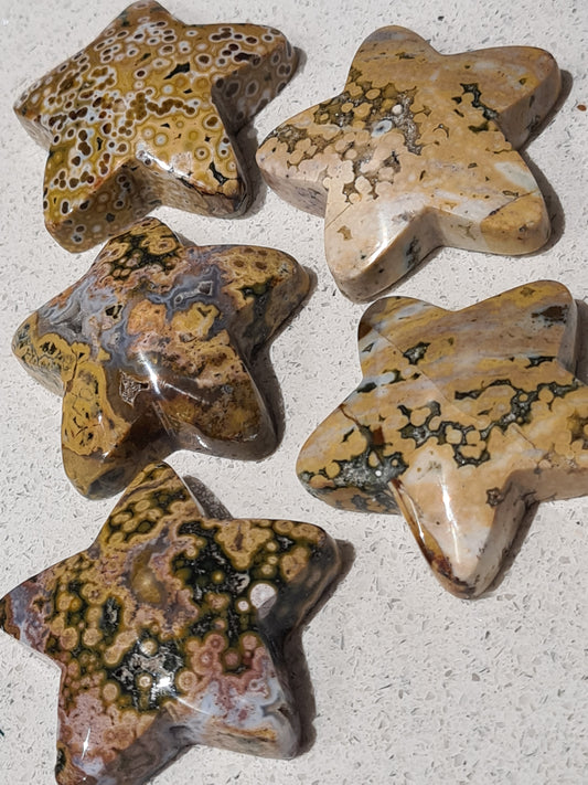 Collection of Orbicular Jasper Star Carvings, raised top and flat back. In colours of yellow, green and white with druzy quartz pockets. On white background