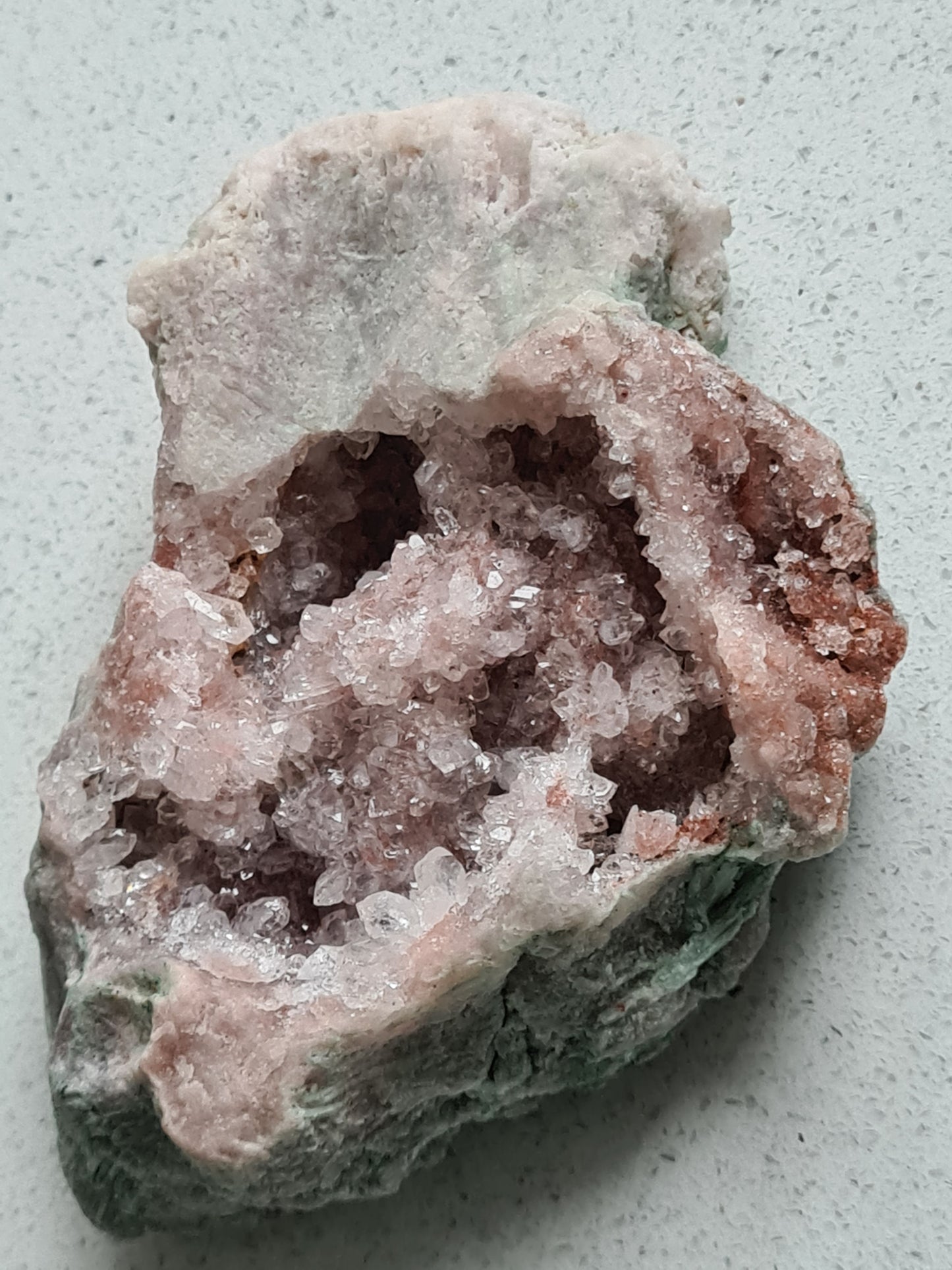 A pink amethyst raw half geode with light to dark pink druzy