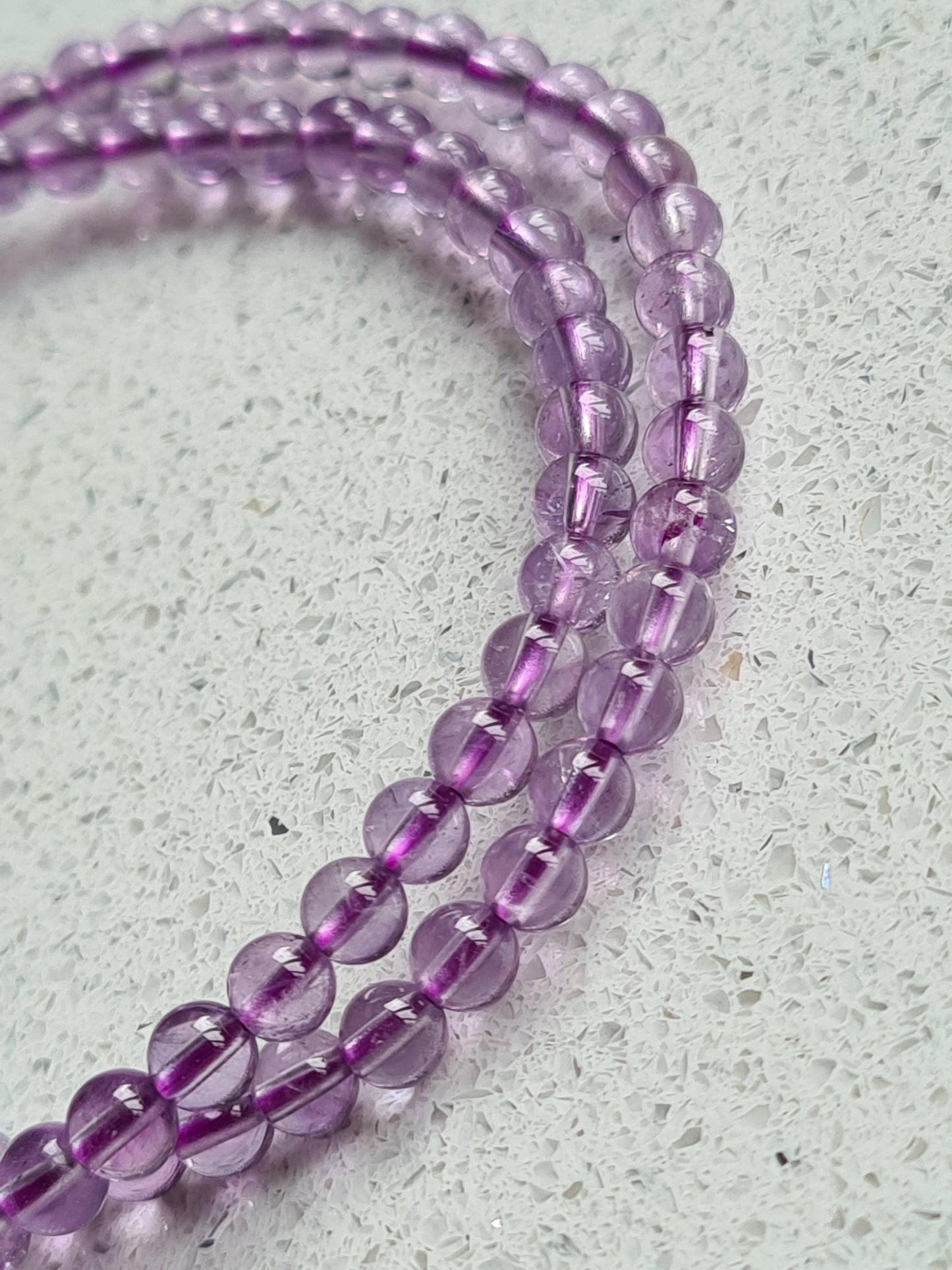 Two 4mm round lilac amethyst beaded bracelets on a white background