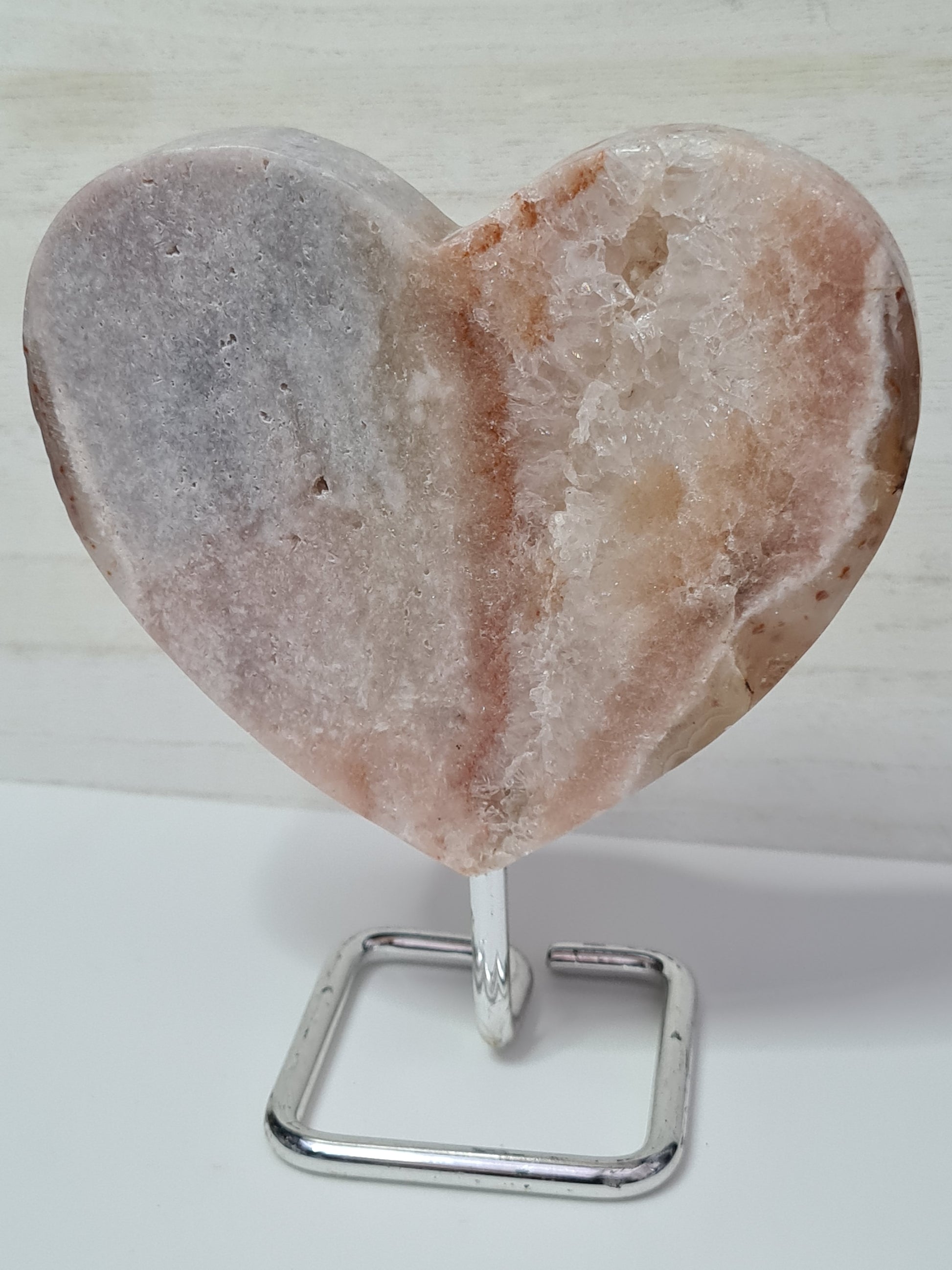 A beautiful banded heart of pink and lilac amethyst on stand with inclusions of golden healer, quartz and chalcedony.