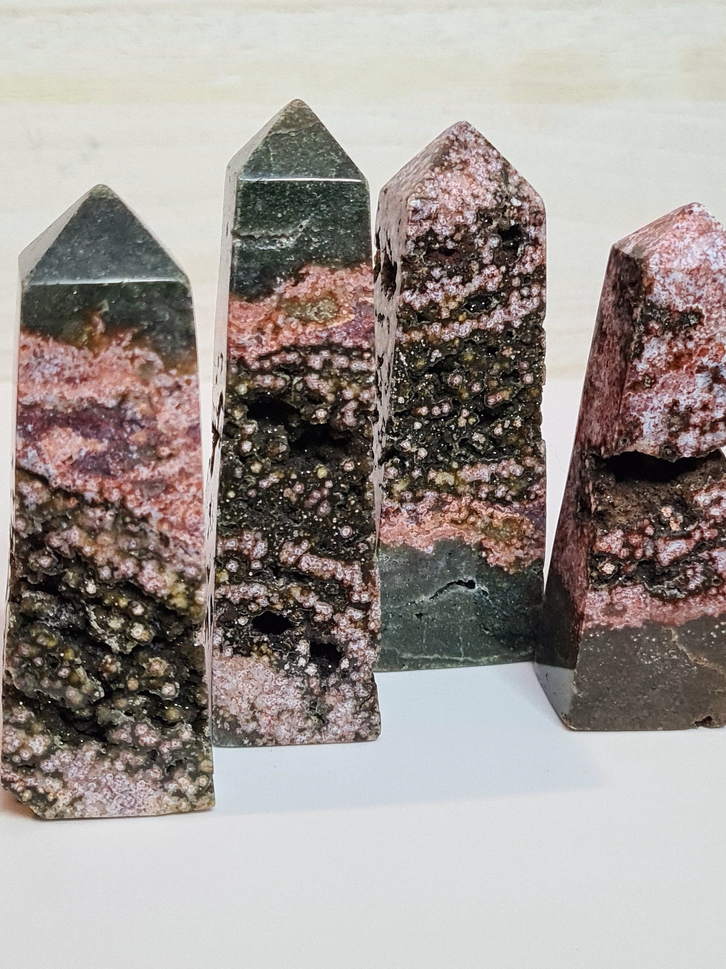 A collection of pink and green orbicular jasper obelisks from Indonesia