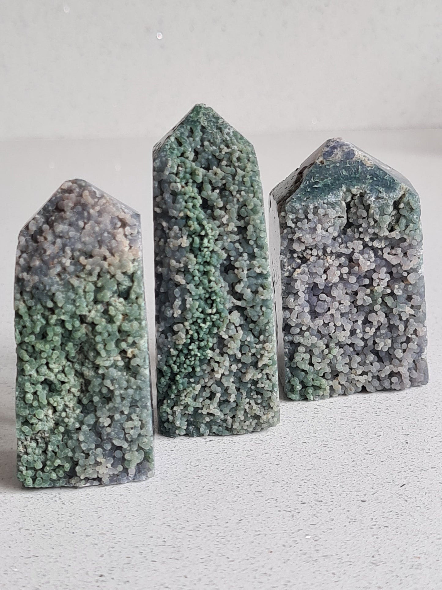 Three natural grape agate obelisks with botroydial formations in green and purple. From Indonesia