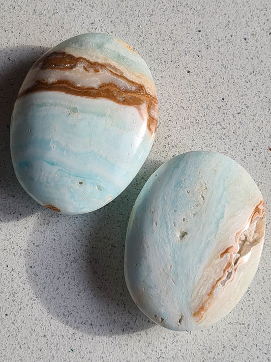 Caribbean Calcite palmstones in ocean blue calcite with brown aragonite banding. One left available