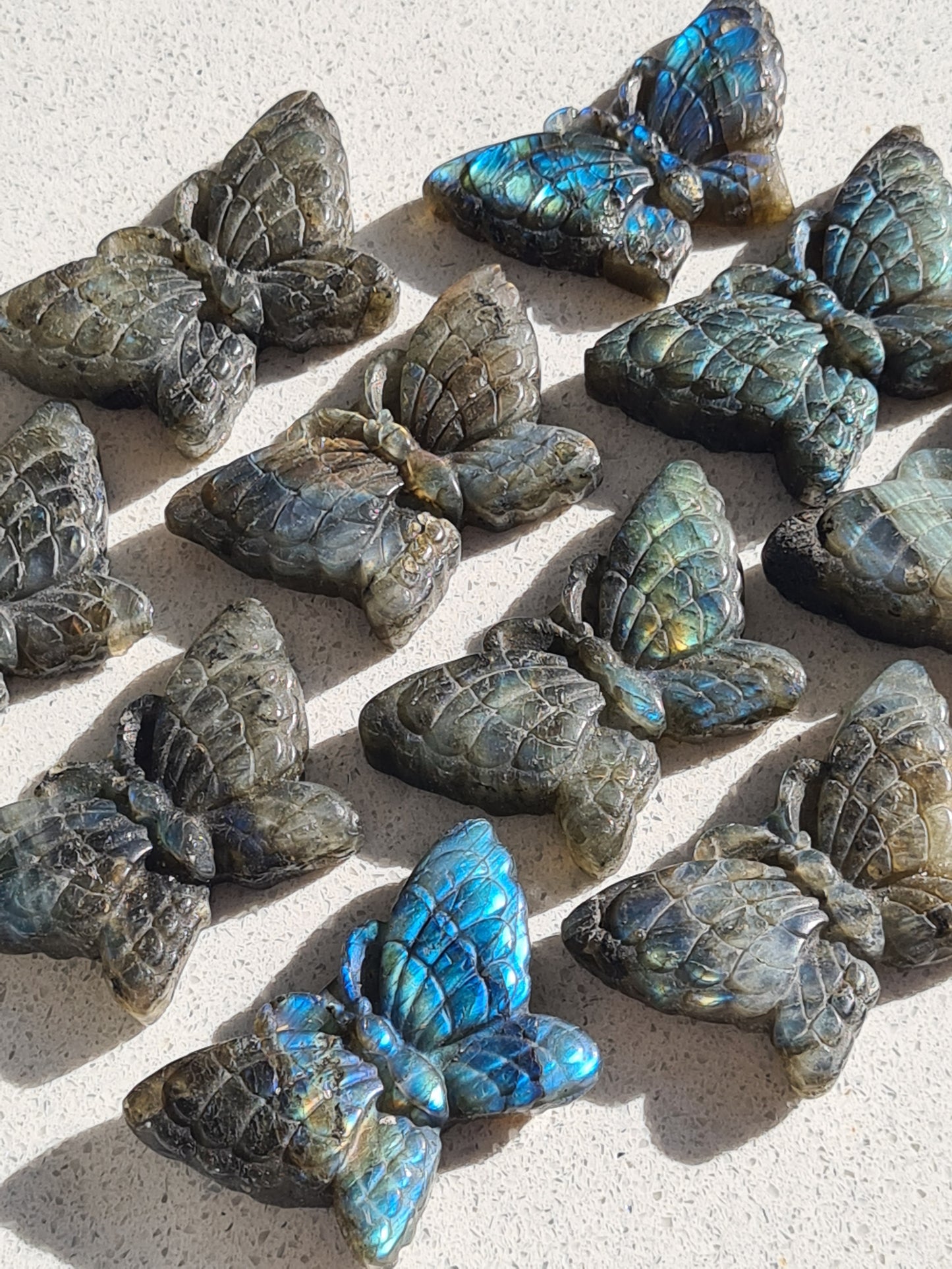 Collection of labradorite butterfly carvings, each with unique labradorescence
