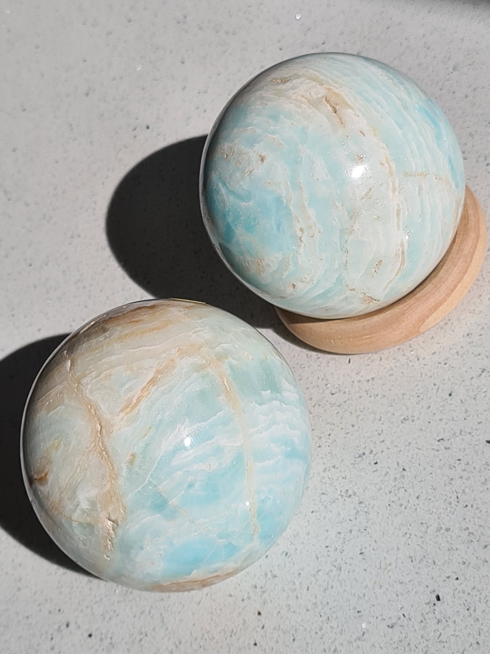 Caribbean Calcite Polished Sphere, with bands of blue calcite and brown/white aragonite.