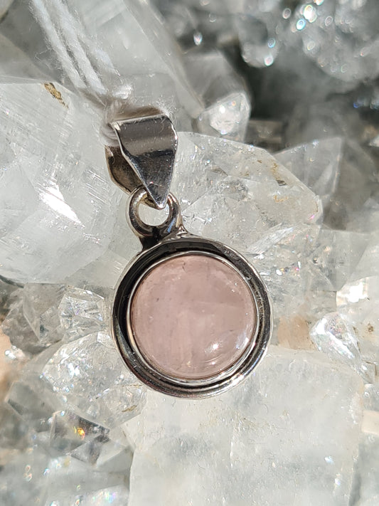 A round rose quartz pendant, with a cabochon rose quartz in silver frame. 