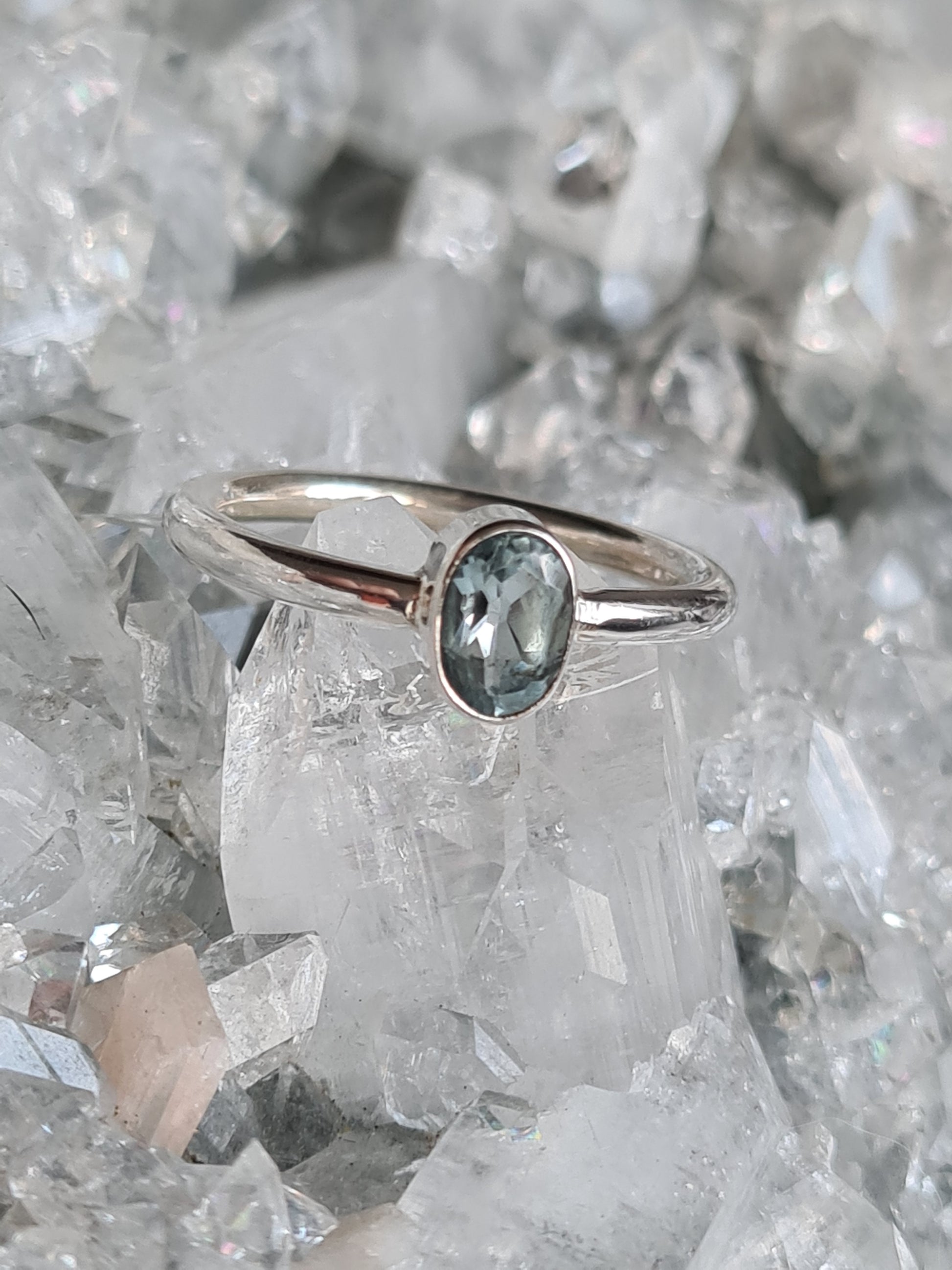 A single oval faceted sky blue topaz set into sterling silver ring. Size UK R