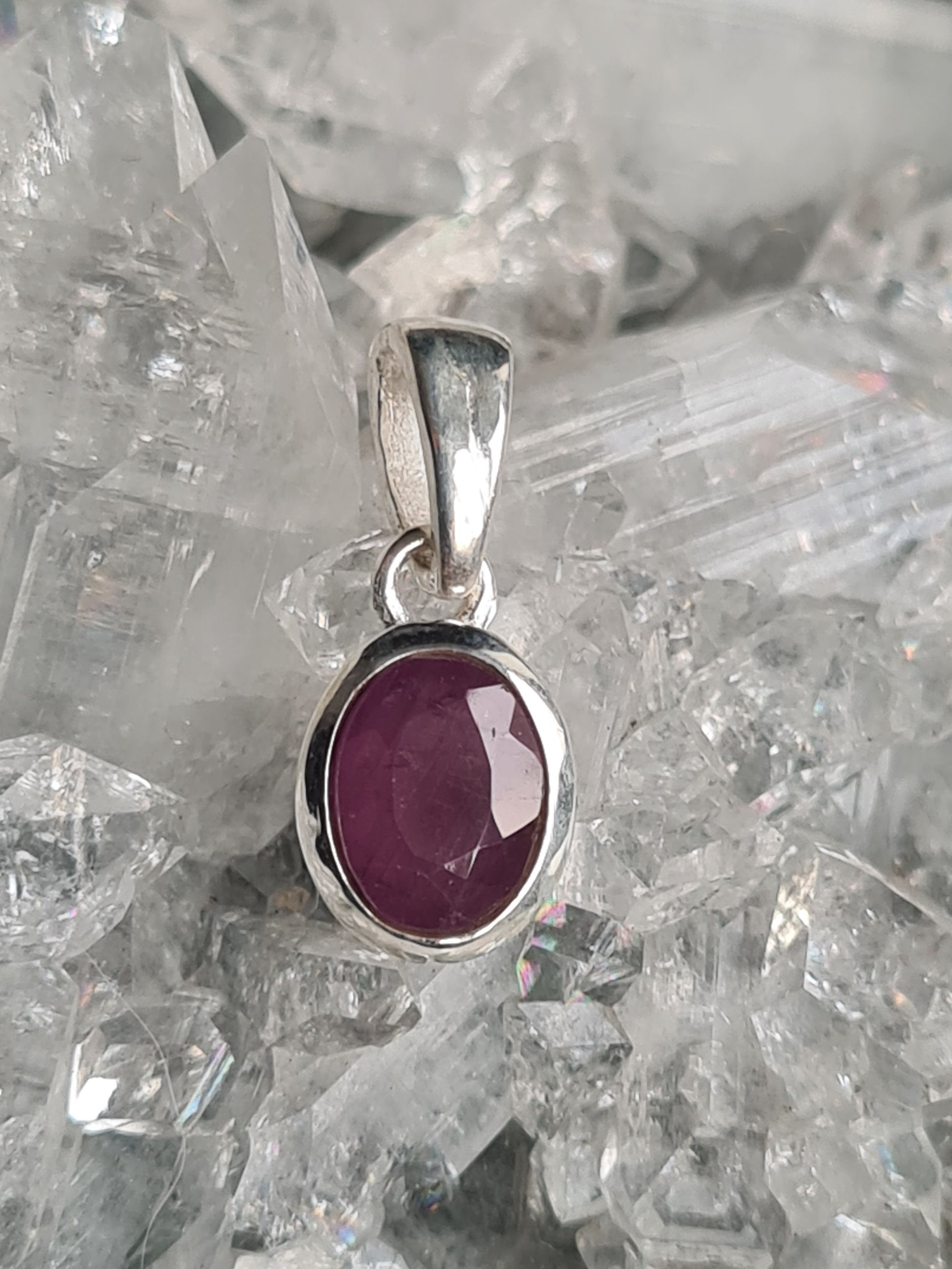 A natural ruby pendant in sterling silver. Oval shaped pinkish-red ruby from India.