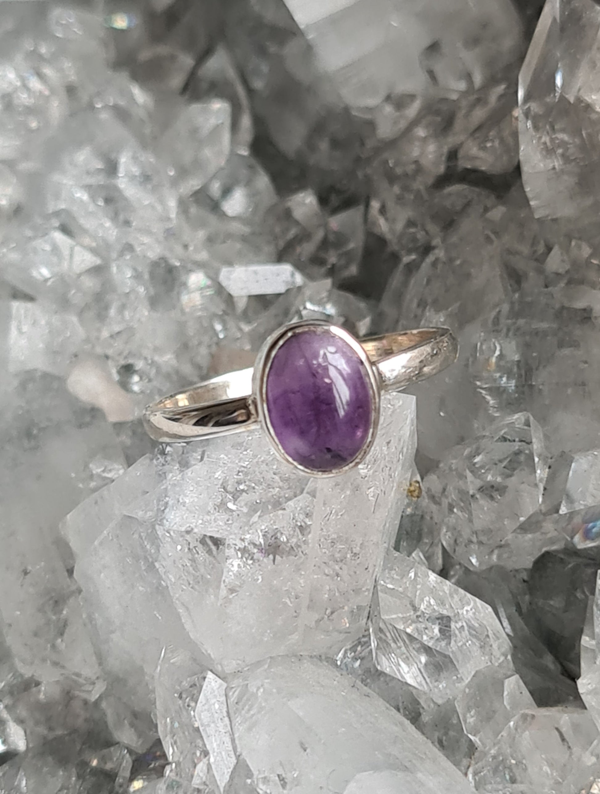 A simple rubover oval amethyst cabochon set ring in sterling silver. Sizes O and Q