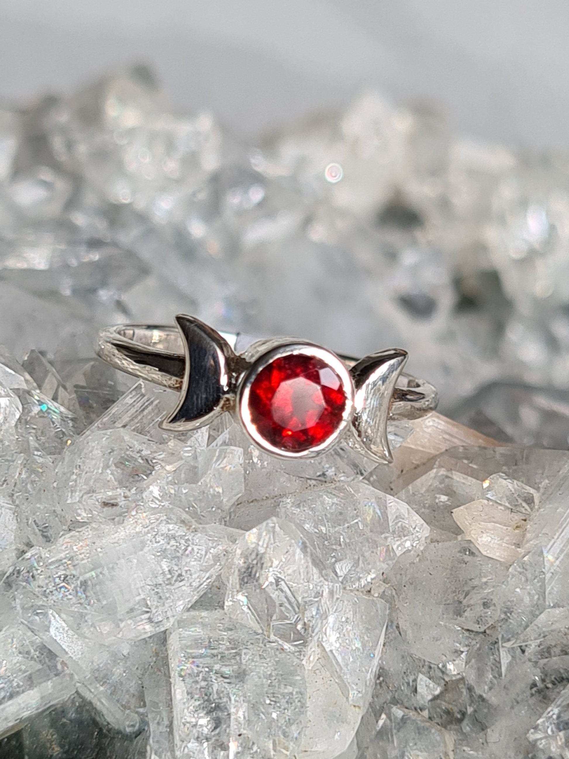 Triple moon ring set with a round faceted red garnet in sterling silver