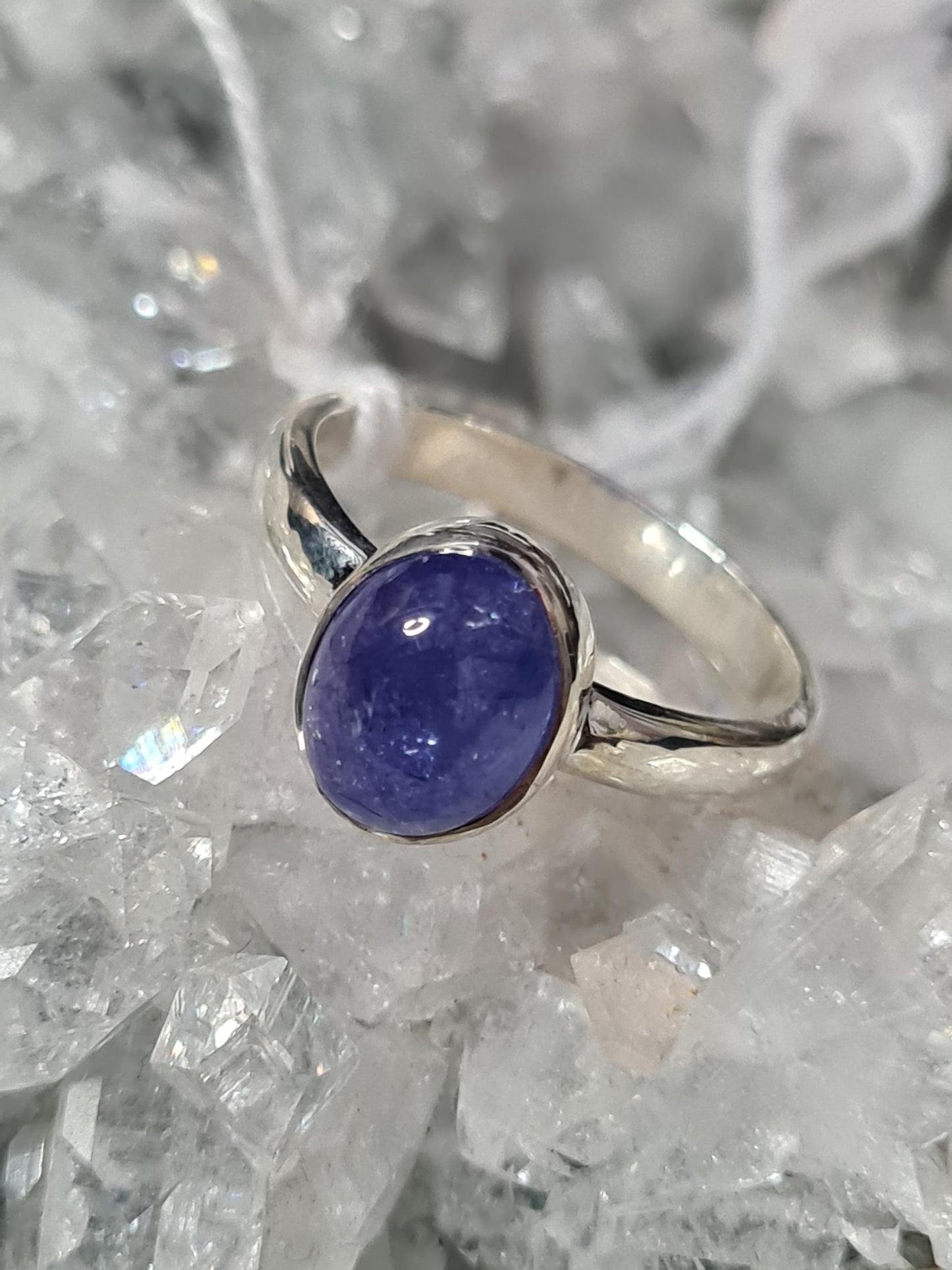 An oval cabochon Tanzanite single stone ring in sterling silver. Size UK Q