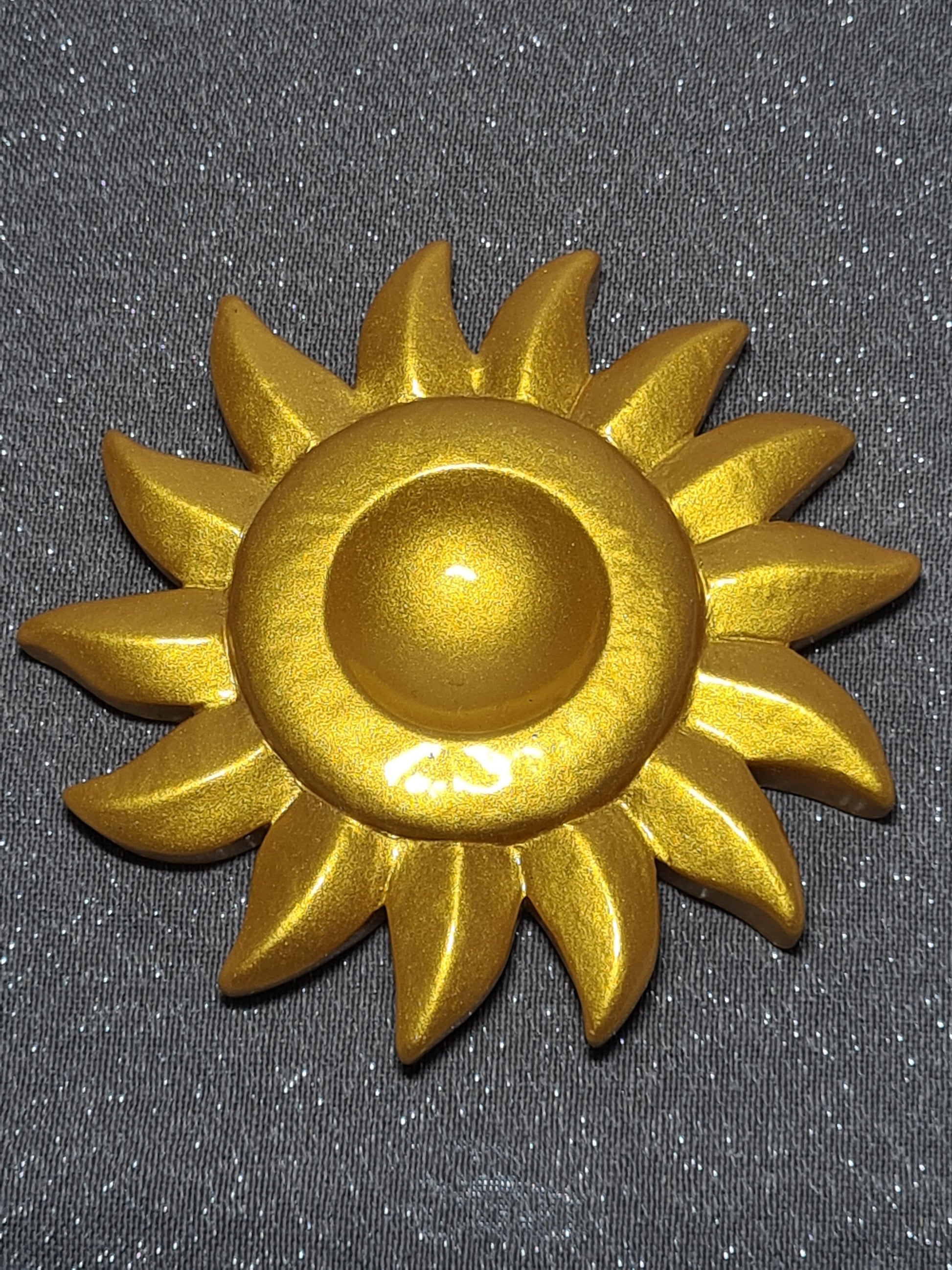 Gold coloured sun design sphere stand.