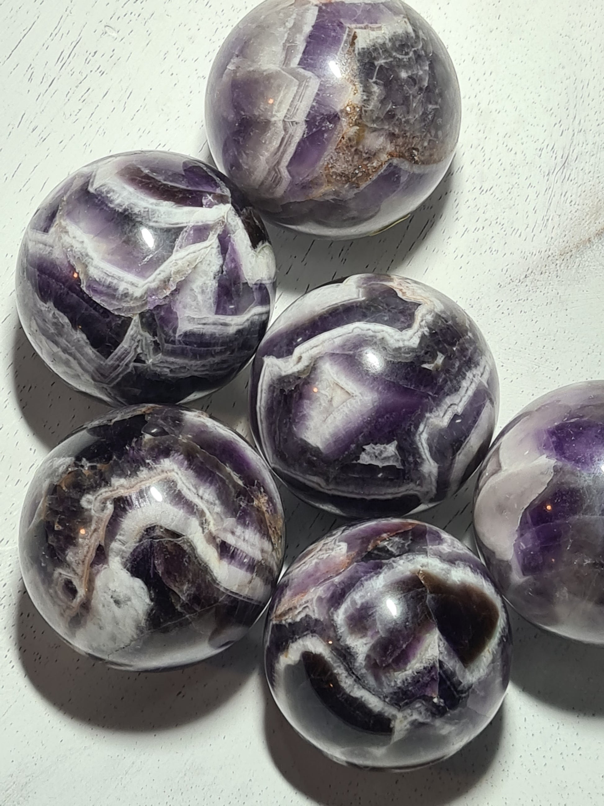Dream Amethyst Spheres with deep purple colour and c;ear quartz chevron shaped banding. measuring between 40mm and 47mm diameter. You choose from the drop down menu.