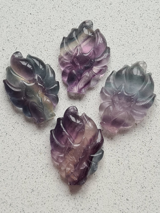 Collection of rainbow fluorite fox carvings in purple, blue and white banded flmuorite