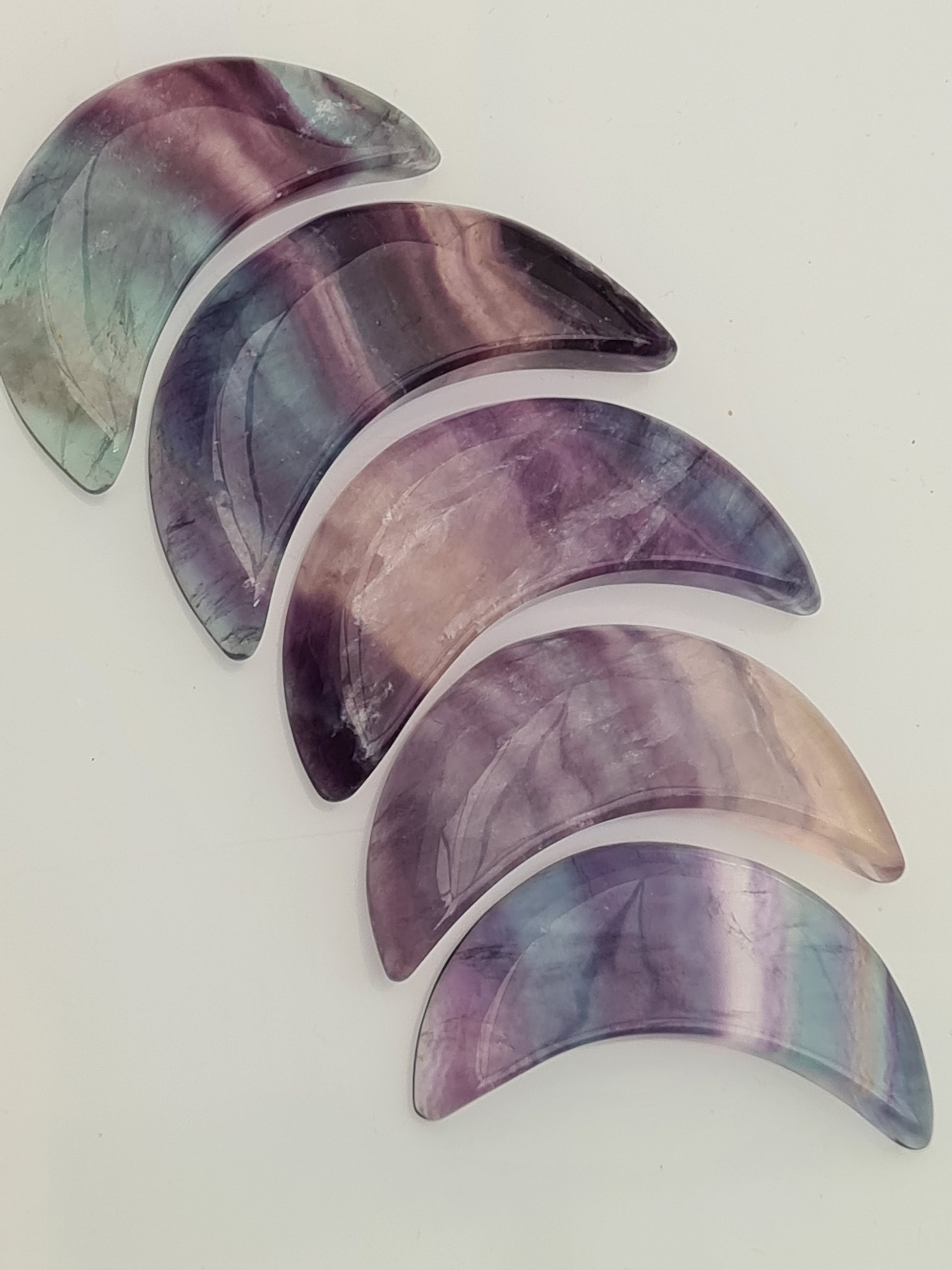 Rainbow Fluorite Crescent Moons, in colours of purple, blue and clear. Five shown on a white background. 