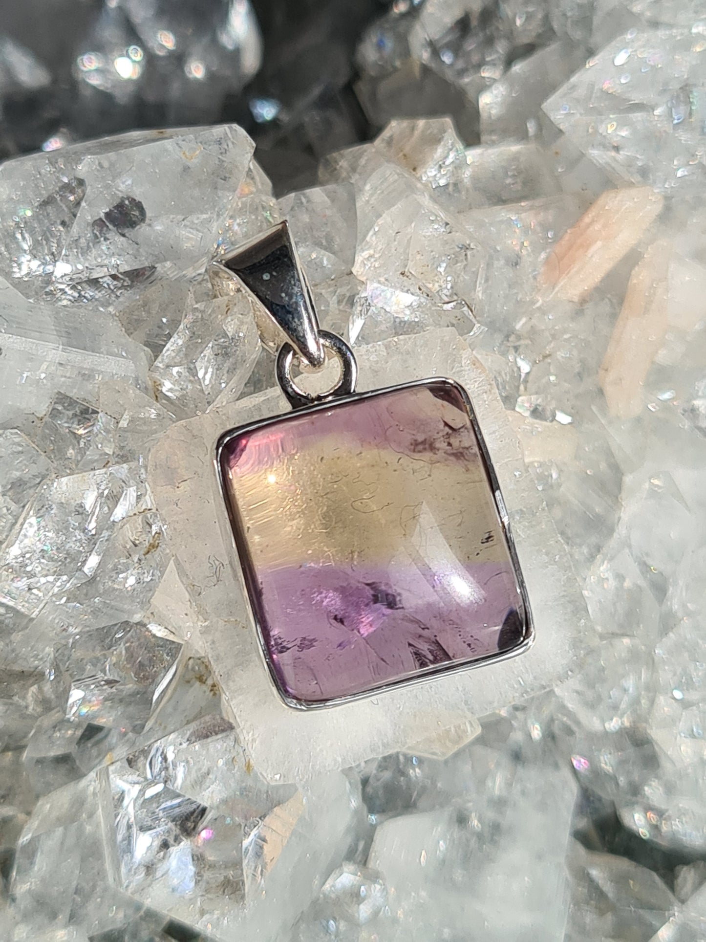 An Ametrine Pendant in Sterling Silver. The Ametrine is cushion shaped with clear zones of Amethyst and Citrine