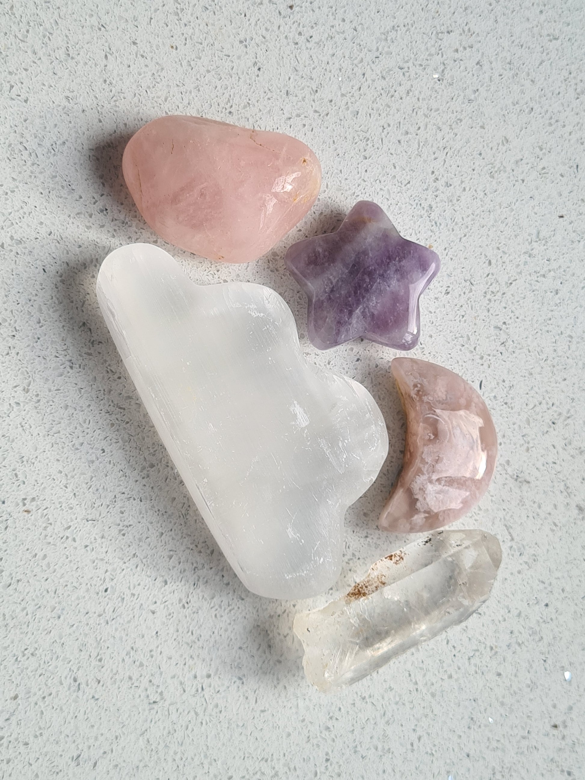 Celestial crystal set containing a selenite cloud, a flower agate moon, a dream amethyst star, a raw lemurian quartz point and a rose quartz tumble.